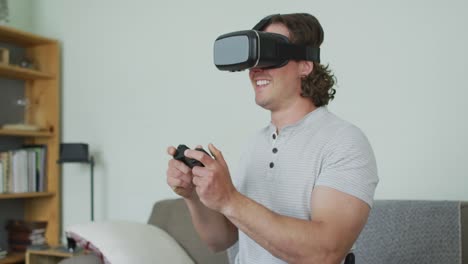 Glücklicher-Kaukasischer-Mann,-Der-Ein-VR-Headset-Trägt-Und-Ein-Gamepad-Im-Wohnzimmer-Hält