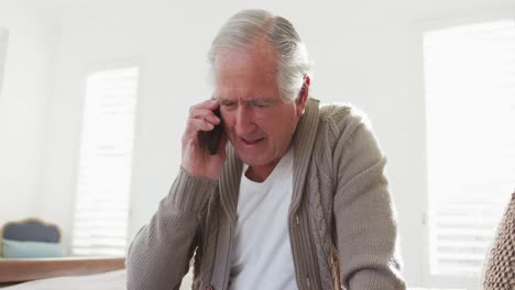 Fröhlicher-älterer-Mann-Im-Ruhestand,-Der-Zu-Hause-Mit-Dem-Handy-Telefoniert