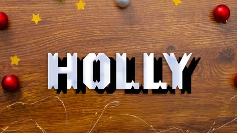 Animation-of-holly-text-over-christmas-baubles-on-wooden-background