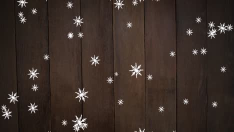 Animation-of-christmas-snowflakes-falling-over-brown-wooden-background