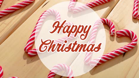 Animation-of-happy-christmas-text-over-candies-on-wooden-background