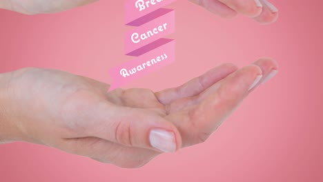 Animation-of-breast-cancer-awareness-text-on-pink-ribbon,-over-hands-of-woman,-on-pink