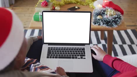 African-american-mother-with-daughter-making-laptop-christmas-video-call,-with-copy-space-on-screen