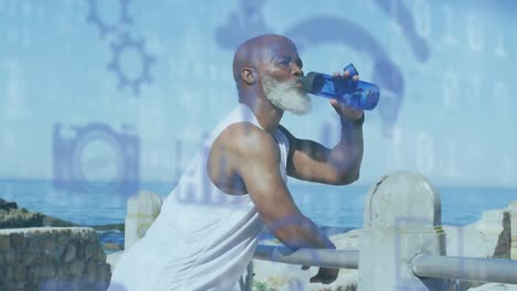 Animation-Von-Mediensymbolen-über-Einem-älteren-Afroamerikanischen-Mann,-Der-Am-Strand-Wasser-Trinkt