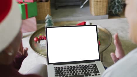 Waving-diverse-senior-female-friends-making-laptop-christmas-video-call,-copy-space-on-screen