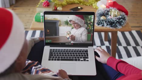 Afroamerikanische-Mutter-Und-Tochter-Nutzen-Laptop-Für-Einen-Weihnachtsvideoanruf-Mit-Einem-Jungen-Auf-Dem-Bildschirm