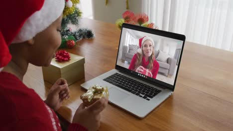 Afroamerikanische-Frau-Mit-Weihnachtsmütze-Nutzt-Laptop-Für-Weihnachtsvideoanruf-Mit-Frau-Auf-Dem-Bildschirm