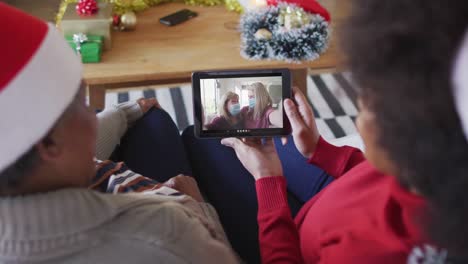Afroamerikanische-Mutter-Und-Tochter-Nutzen-Ein-Tablet-Für-Einen-Weihnachtsvideoanruf-Mit-Der-Familie-Auf-Dem-Bildschirm