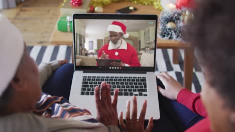 Afroamerikanische-Mutter-Und-Tochter-Nutzen-Laptop-Für-Weihnachtsvideoanruf-Mit-Dem-Weihnachtsmann-Auf-Dem-Bildschirm