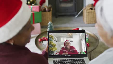 Verschiedene-ältere-Freundinnen-Nutzen-Laptop-Für-Weihnachtsvideoanruf-Mit-Lächelnder-Frau-Auf-Dem-Bildschirm