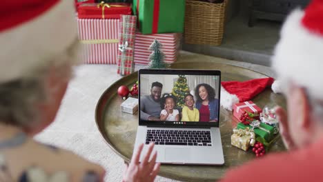 Älteres-Kaukasisches-Paar-Nutzt-Laptop-Für-Weihnachtsvideoanruf-Mit-Glücklicher-Familie-Auf-Dem-Bildschirm