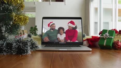 Lächelnde-Afroamerikanische-Familie-Mit-Weihnachtsmützen-Bei-Weihnachtsvideoanruf-Auf-Dem-Laptop