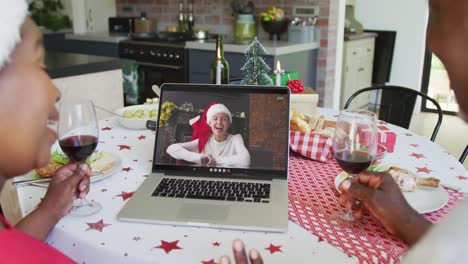Afroamerikanisches-Paar-Mit-Wein-Und-Laptop-Für-Weihnachtsvideoanruf-Mit-Glücklicher-Frau-Auf-Dem-Bildschirm