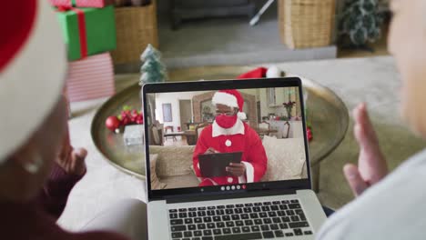 Verschiedene-ältere-Freundinnen-Nutzen-Laptop-Für-Weihnachtsvideoanruf-Mit-Dem-Weihnachtsmann-Auf-Dem-Bildschirm