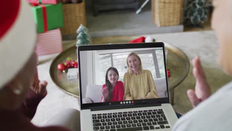 Verschiedene-ältere-Freundinnen-Nutzen-Laptop-Für-Weihnachtsvideoanruf-Mit-Glücklicher-Familie-Auf-Dem-Bildschirm