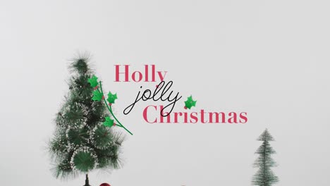 Animation-of-holly-christmas-text-over-fir-tree