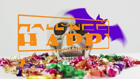 Animation-of-happy-halloween-text-over-skull-and-sweets