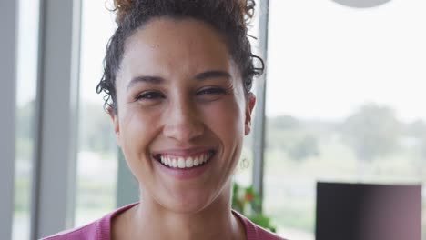 Portrait-of-smiling-biracial-creative-businesswoman-in-modern-office-interior