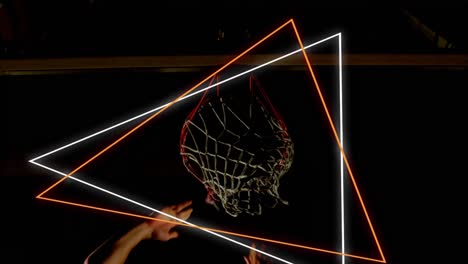 Animation-of-orange-and-white-neon-triangles-over-basketball-player-scoring-hoop