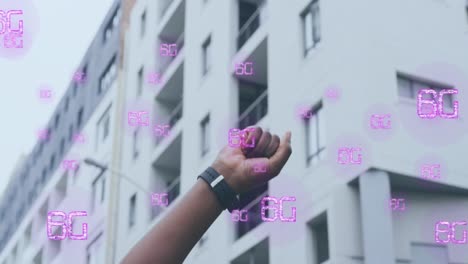 Animation-of-6g-in-pink-text-over-african-american-woman-raising-fist-in-city-street