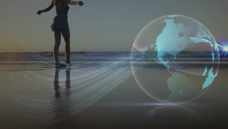 Animation-of-glowing-global-network-over-woman-walking-on-sandy-beach