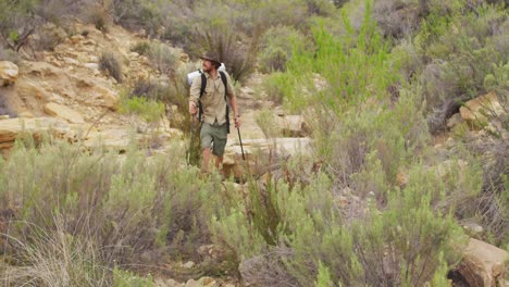 Un-Hombre-Caucásico-De-Supervivencia-Caminando-Por-El-Desierto-Con-Mochila-Y-Bastones-Para-Caminar.