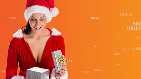 Animation-of-holly-text-and-smiling-woman-in-santa-costume-opening-christmas-present,-on-orange