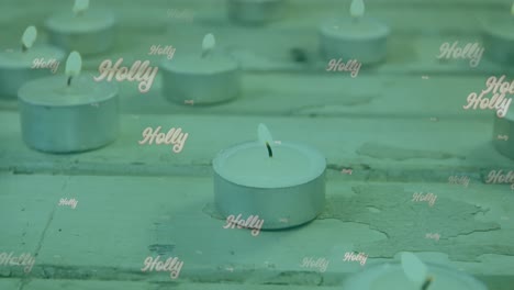 Animation-of-holly-text-in-white,-on-green-over-christmas-tea-light-candles-burning