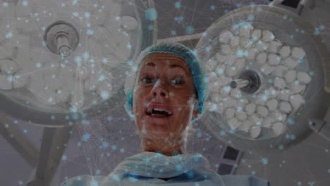 Animation-of-network-of-connections-over-female-surgeon-talking-in-operating-theatre