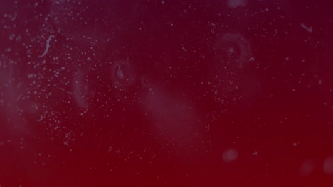 Animation-of-white-moving-spots-on-red-background