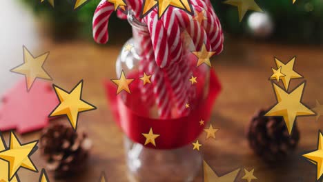 Animation-Von-Goldenen-Sternen,-Die-Sich-über-Weihnachtliche-Zuckerstangen-Und-Dekorationen-Bewegen