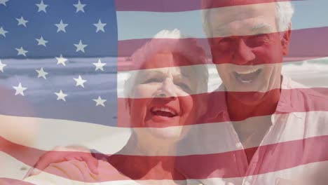 Animation-of-happy-senior-caucasian-couple-embracing-on-beach-over-flag-of-united-states-of-america