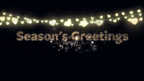 Animation-of-gold-text-season's-greetings,-with-string-of-heart-fairy-lights-and-fireworks,-on-black