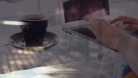 Animation-of-hands-of-woman-with-coffee-using-laptop,-over-sped-up-commuters-walking-in-city