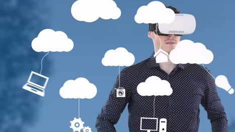Animation-of-businessman-wearing-vr-headset-and-digital-clouds-with-electronic-devices