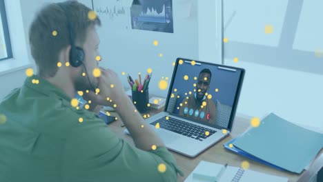 Animation-of-bitcoin-icons-over-caucasian-man-using-phone-headset-and-laptop