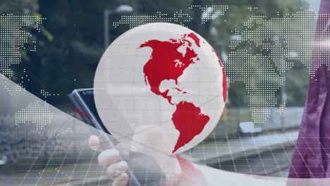 Animation-of-red-and-white-globe-and-map,-over-businesswoman-at-station-using-smartphone