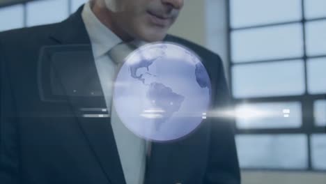 Animation-of-grey-globe-over-caucasian-businessman-using-tablet