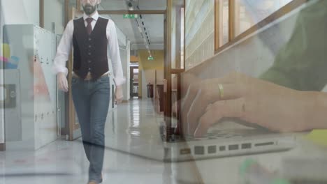 Animation-of-hands-using-laptop-over-businessman-walking-in-office-corridor