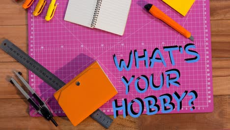 Animation-of-what's-your-hobby-text-in-blue-over-craft-tools-on-cutting-mat