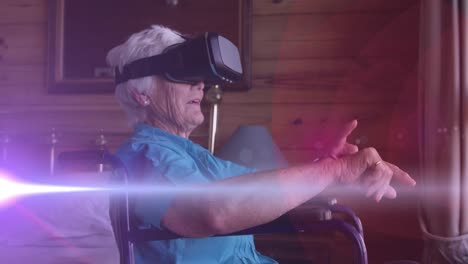 Animation-of-light-moving-over-senior-woman-in-wheelchair-using-vr-headset