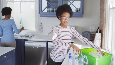 Glückliche-Afroamerikanische-Mutter-Und-Tochter,-Die-Gemeinsam-In-Der-Küche-Recyceln