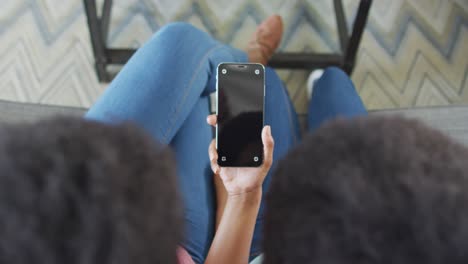 African-american-mother-and-daughter-using-smartphone-with-copy-space-on-screen
