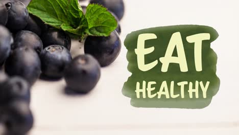 Animation-of-eat-healthy-text-in-green-over-fresh-organic-blueberries