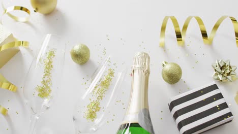 Decorations-and-champagne-on-white-background-at-new-year's-eve