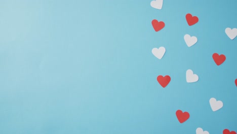 Multiple-red-and-pink-paper-hearts-at-valentine's-day-on-blue-background