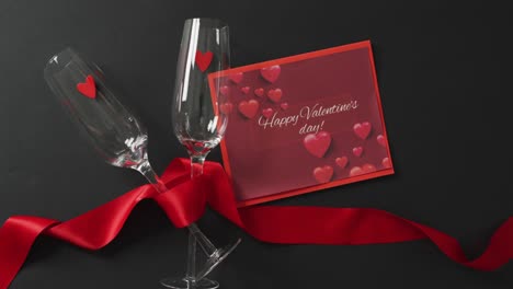 Happy-valentine's-day-text-over-champagne-glasses-with-hearts-and-red-ribbon