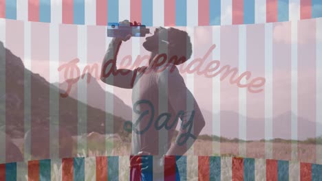 Animation-of-independence-day-text-over-african-american-man-drinking-water-in-mountains