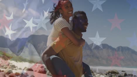 Animation-of-american-flag-over-smiling-diverse-couple-carrying-in-mountains