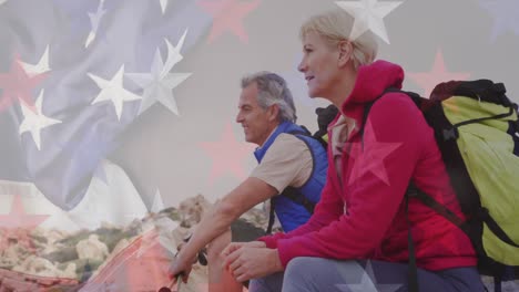 Animation-of-flag-of-united-states-of-america-over-senior-couple-taking-break-hiking-in-mountains
